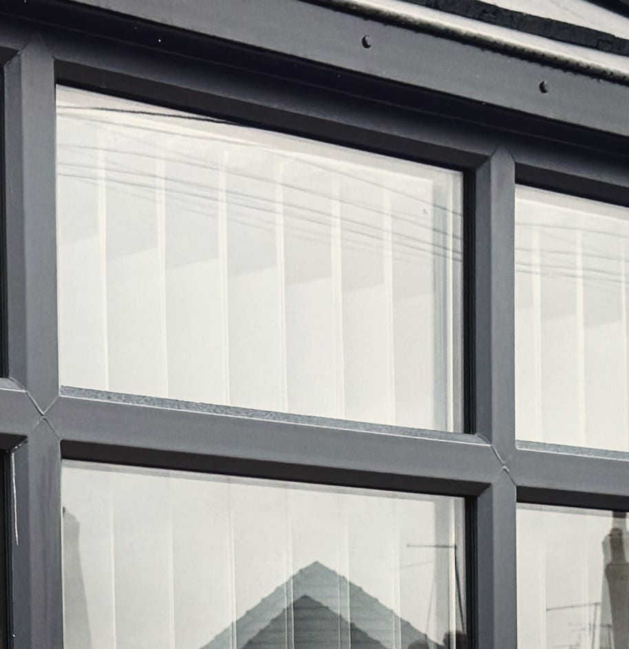 Close view of the welded corner and transom junction on an anthracite grey uPVC frame, with the glazing bead seated square