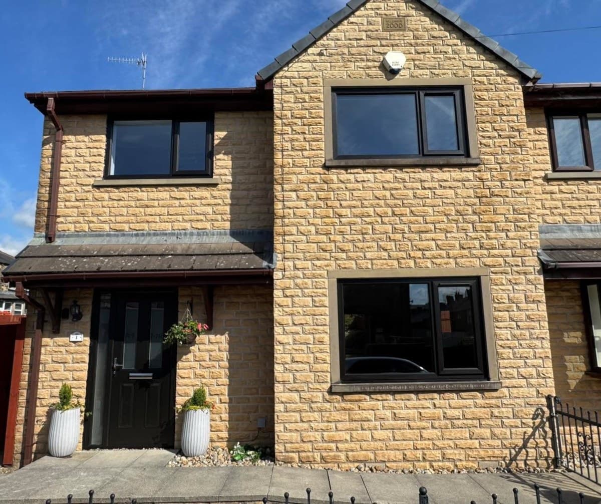 A gritstone detached house with anthracite uPVC windows