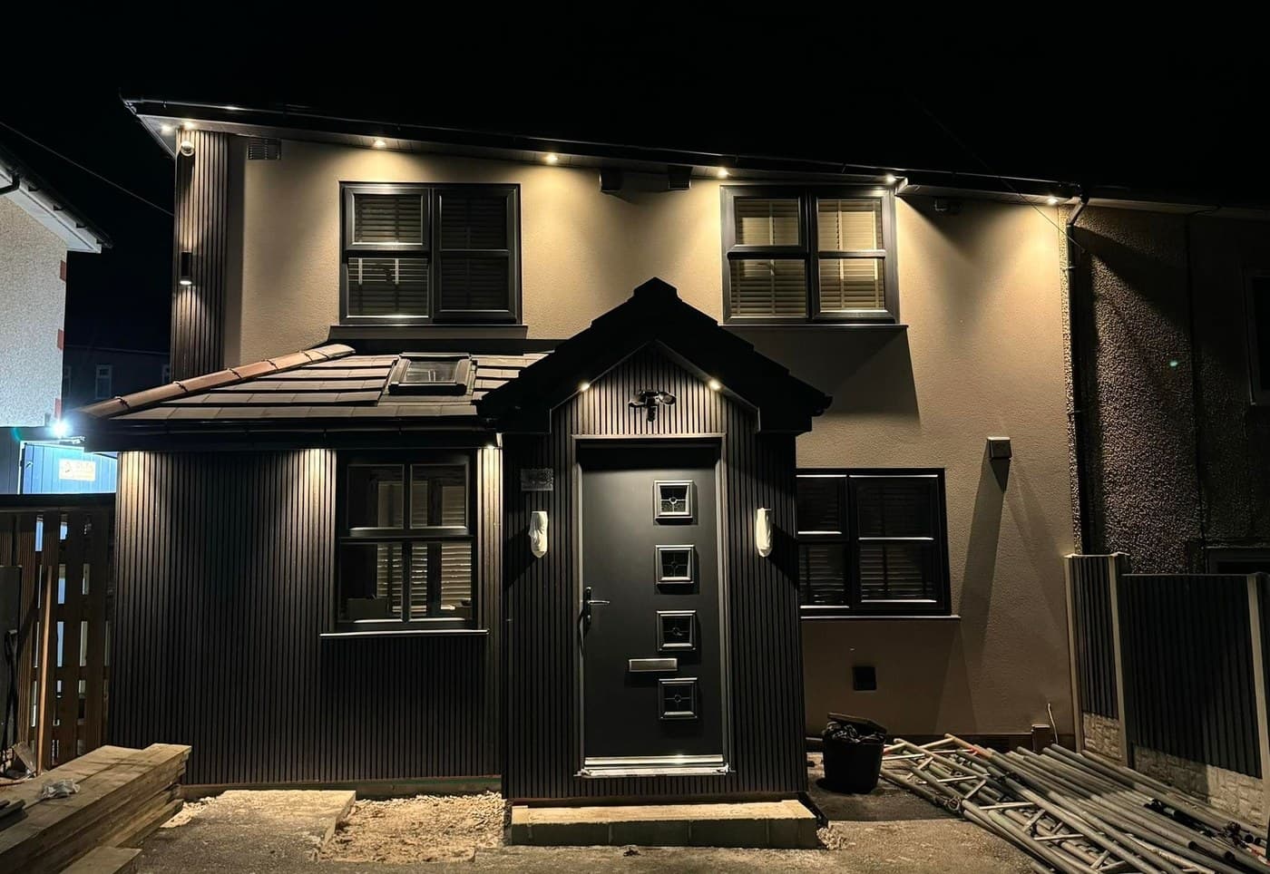 A house at dusk, its new porch, composite door and windows lit from above